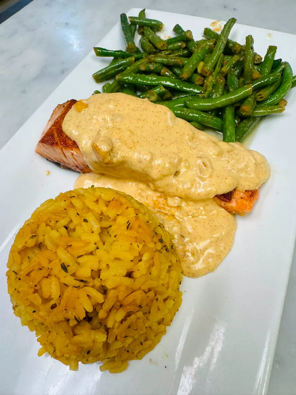 Pan-seared salmon with Dijon cream sauce, yellow rice and sauteed green beans, a Minisink Hotel daily special